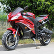 Load image into Gallery viewer, Red sports motorcycle parked on pavement with green foliage in the background.